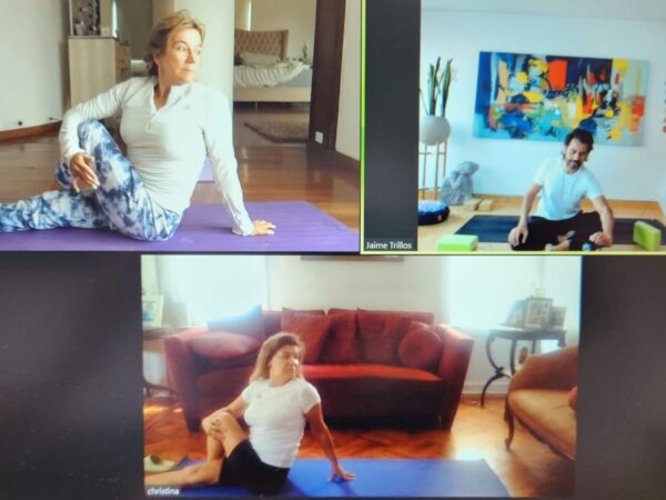 2 Personas por Clase Personalizada Explorando la Variabilidad de Posturas en una Clase Virtual de Yoga. Instructor Jaime Trillos lidera la sesión con dos estudiantes, cada uno inmerso en su propia práctica única